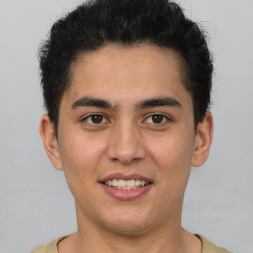 Joyful latino young-adult male with short  brown hair and brown eyes