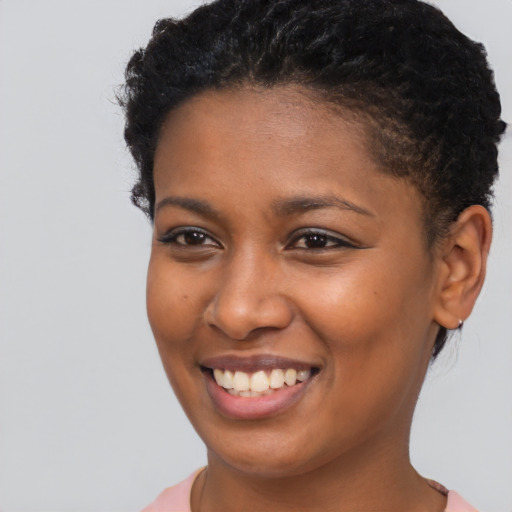 Joyful black young-adult female with short  brown hair and brown eyes