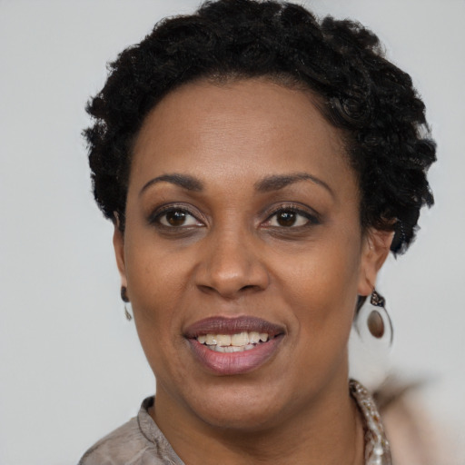 Joyful black adult female with short  black hair and brown eyes