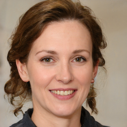 Joyful white adult female with medium  brown hair and grey eyes