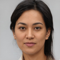 Joyful latino young-adult female with medium  brown hair and brown eyes