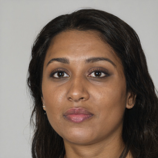 Joyful black young-adult female with long  black hair and brown eyes