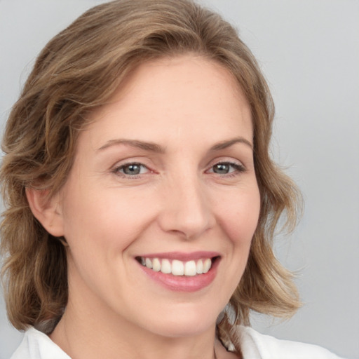 Joyful white young-adult female with medium  brown hair and blue eyes