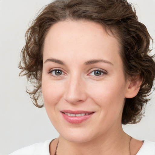 Joyful white young-adult female with medium  brown hair and green eyes