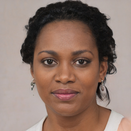Joyful black adult female with short  black hair and brown eyes