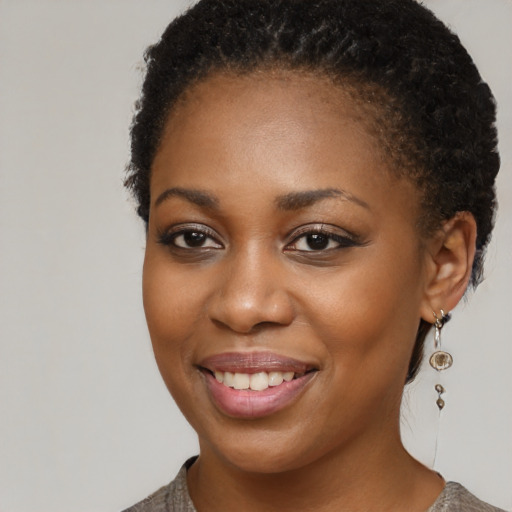 Joyful black young-adult female with short  brown hair and brown eyes