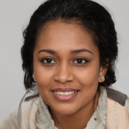 Joyful black young-adult female with medium  brown hair and brown eyes