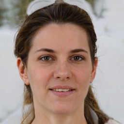 Joyful white young-adult female with medium  brown hair and grey eyes