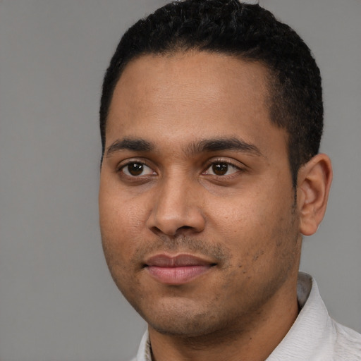 Joyful black young-adult male with short  black hair and brown eyes