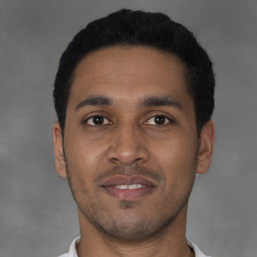 Joyful latino young-adult male with short  black hair and brown eyes