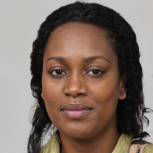 Joyful black young-adult female with long  black hair and brown eyes