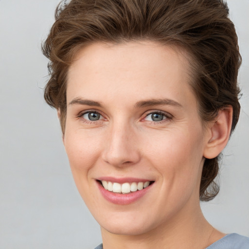 Joyful white young-adult female with short  brown hair and grey eyes