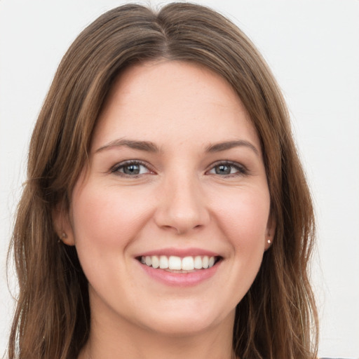 Joyful white young-adult female with long  brown hair and green eyes