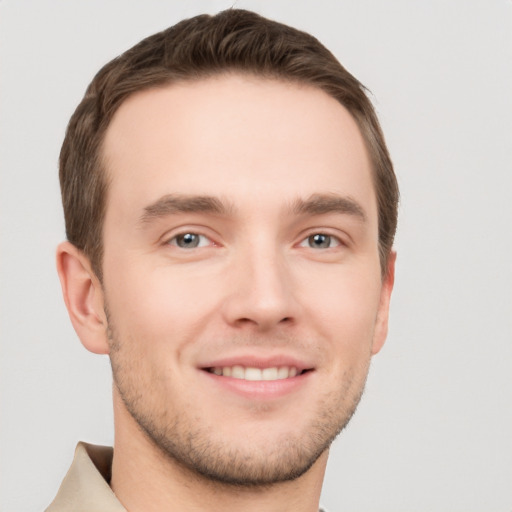 Joyful white young-adult male with short  brown hair and grey eyes