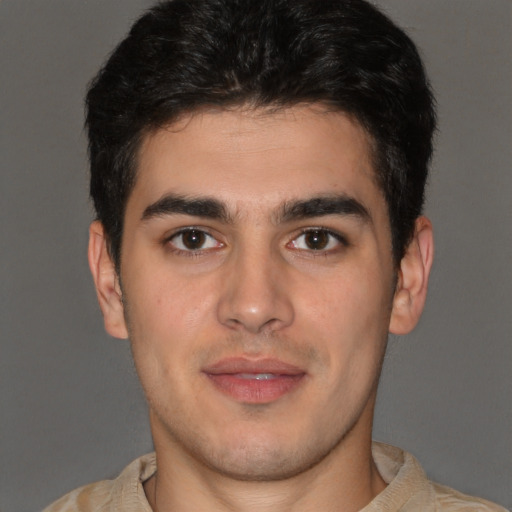 Joyful latino young-adult male with short  brown hair and brown eyes