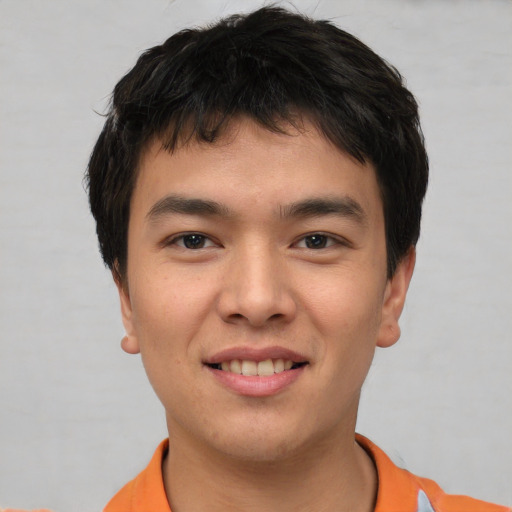 Joyful asian young-adult male with short  brown hair and brown eyes