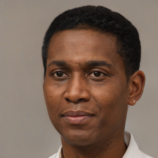 Joyful black young-adult male with short  black hair and brown eyes