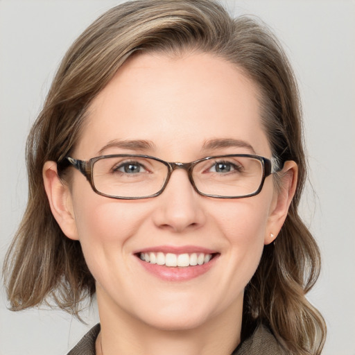 Joyful white adult female with medium  brown hair and blue eyes