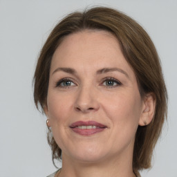 Joyful white adult female with medium  brown hair and grey eyes