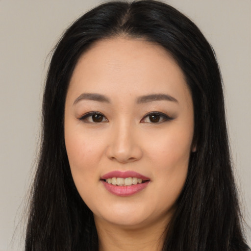 Joyful asian young-adult female with long  black hair and brown eyes