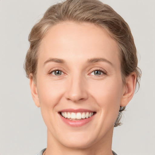 Joyful white young-adult female with short  brown hair and grey eyes