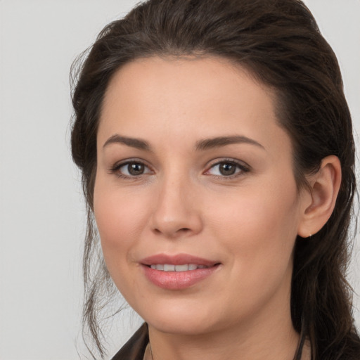 Joyful white young-adult female with long  brown hair and brown eyes