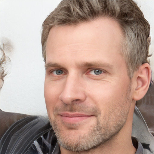 Joyful white adult male with short  brown hair and grey eyes