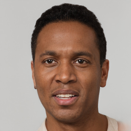 Joyful black adult male with short  black hair and brown eyes
