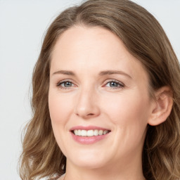 Joyful white young-adult female with long  brown hair and blue eyes