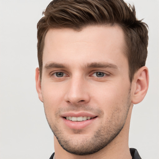 Joyful white young-adult male with short  brown hair and grey eyes