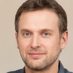 Joyful white adult male with short  brown hair and grey eyes