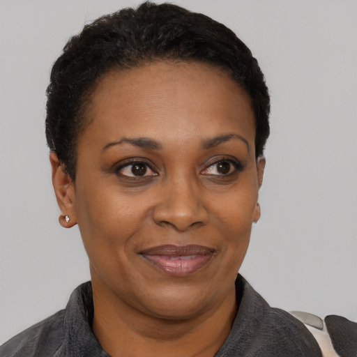 Joyful black adult female with short  black hair and brown eyes