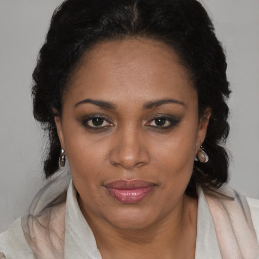 Joyful latino adult female with medium  brown hair and brown eyes