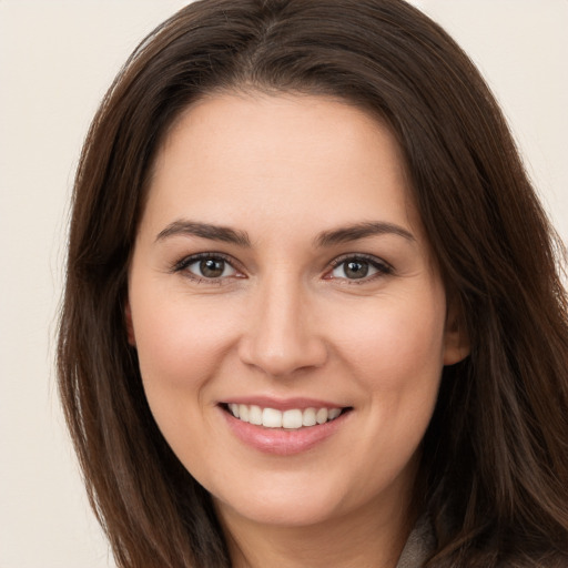 Joyful white young-adult female with long  brown hair and brown eyes