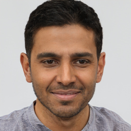 Joyful latino young-adult male with short  brown hair and brown eyes