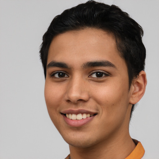 Joyful latino young-adult male with short  black hair and brown eyes