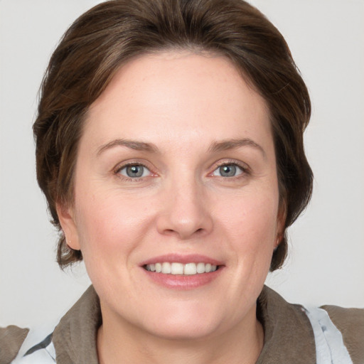 Joyful white adult female with medium  brown hair and grey eyes