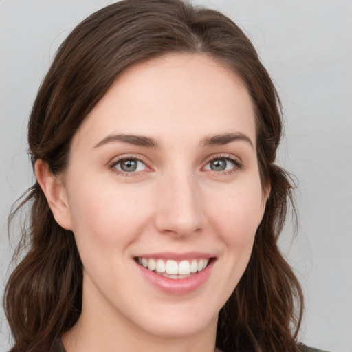 Joyful white young-adult female with long  brown hair and grey eyes