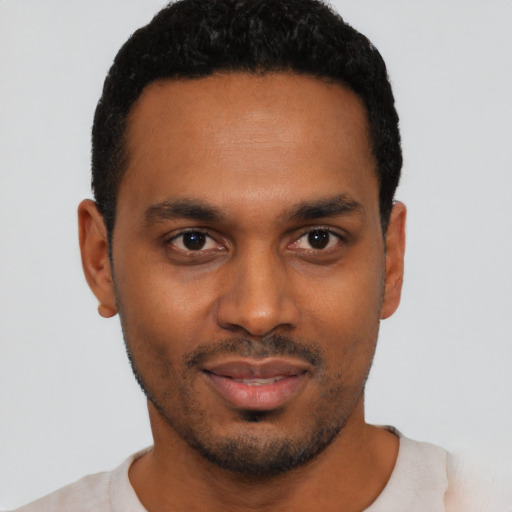 Joyful black young-adult male with short  black hair and brown eyes