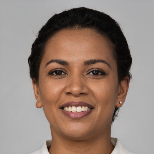 Joyful latino young-adult female with short  black hair and brown eyes
