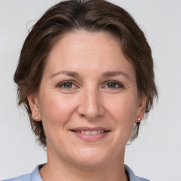 Joyful white adult female with medium  brown hair and grey eyes