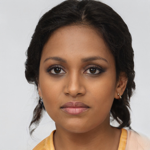 Joyful black young-adult female with long  brown hair and brown eyes