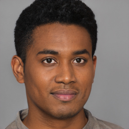 Joyful black young-adult male with short  black hair and brown eyes