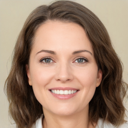 Joyful white young-adult female with medium  brown hair and green eyes