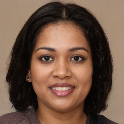 Joyful black young-adult female with medium  brown hair and brown eyes
