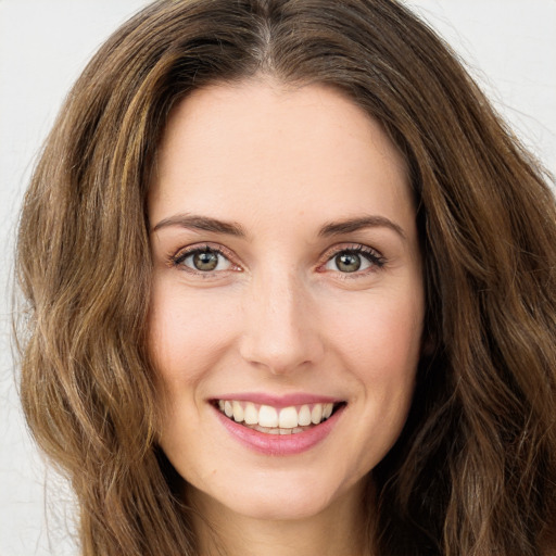 Joyful white young-adult female with long  brown hair and green eyes