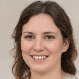 Joyful white young-adult female with medium  brown hair and green eyes