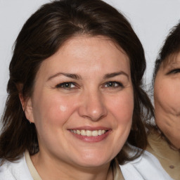 Joyful white adult female with medium  brown hair and brown eyes