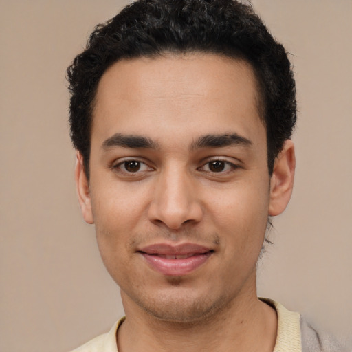 Joyful latino young-adult male with short  black hair and brown eyes