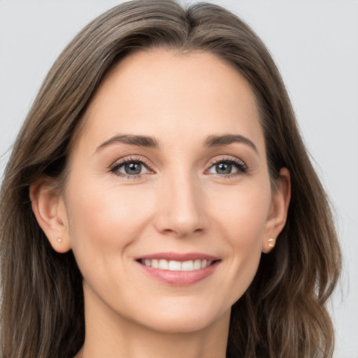 Joyful white young-adult female with long  brown hair and brown eyes